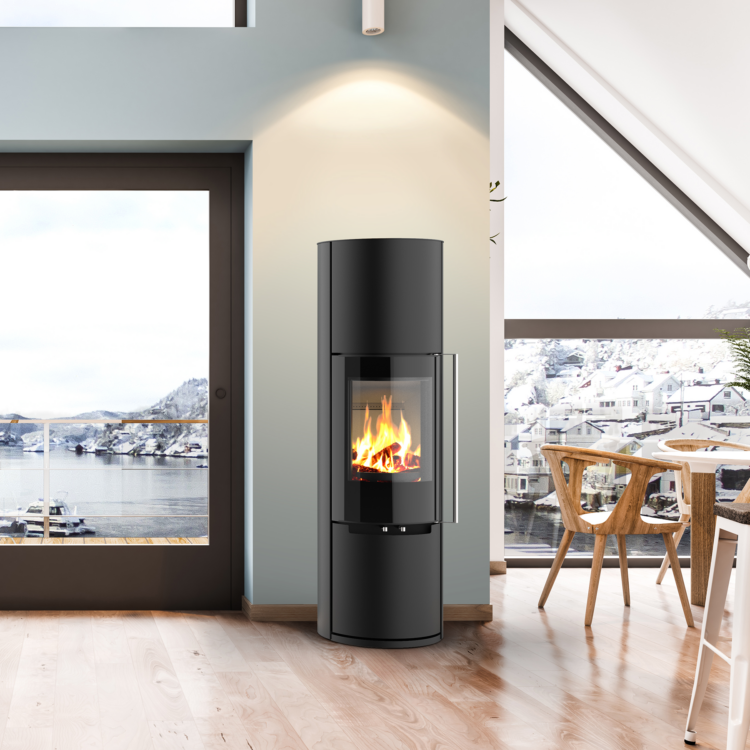 photo ambiance poêle à bois Fusion'L de Morvan, puissant et économique avec une puissance de 7 kW et un rendement de 87 %. Doté d'une finition élégante en pierre naturelle pour une meilleure rétention de la chaleur, il utilise une triple combustion pour maximiser l'efficacité. La porte vitrée offre une vue panoramique des flammes, ajoutant une touche de confort visuel à ses hautes performances écologiques.